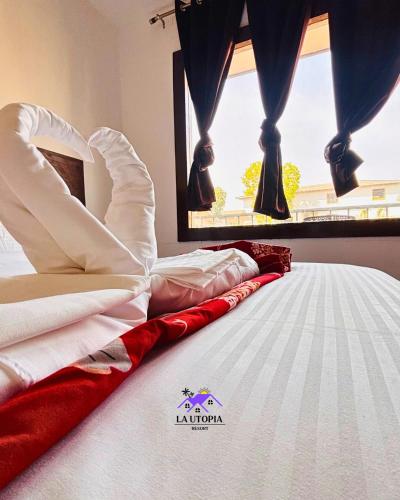 a white bed in a room with a window at La Utopia Resort in Arambol