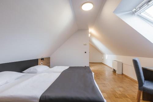 a bedroom with a bed and a chair at Pension Török in Lesce