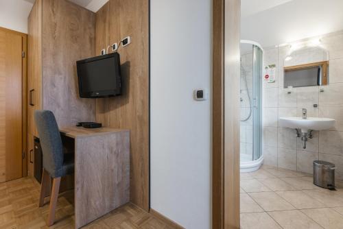 a bathroom with a sink and a tv on a wall at Pension Török in Lesce