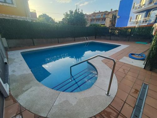 a swimming pool with a metal rail in a yard at Apartamento Noja Playa Trengandin in Noja