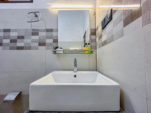 a white sink in a bathroom with a mirror at CAO Ella in Ella
