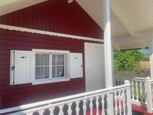 a red house with a window and a porch at Ferienhaus Loretto in Wölzing