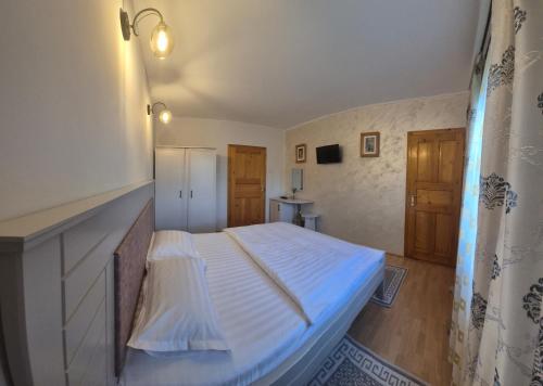 - une petite chambre avec un lit et un réfrigérateur dans l'établissement Casa Sandina, à Vama