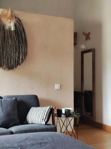 a living room with a blue couch and a mirror at Brin d'Olivier en Luberon in Gargas