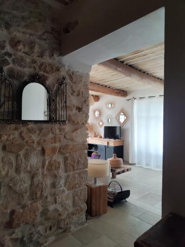 a living room with a stone wall and a chair at Brin d'Olivier en Luberon in Gargas