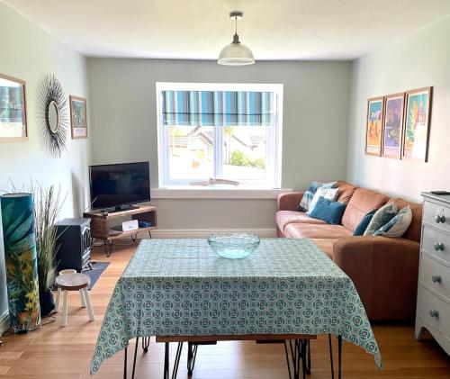 a living room with a table and a couch at Your Saundersfoot getaway - relax explore and make memories at Berts Bungalow in Saundersfoot
