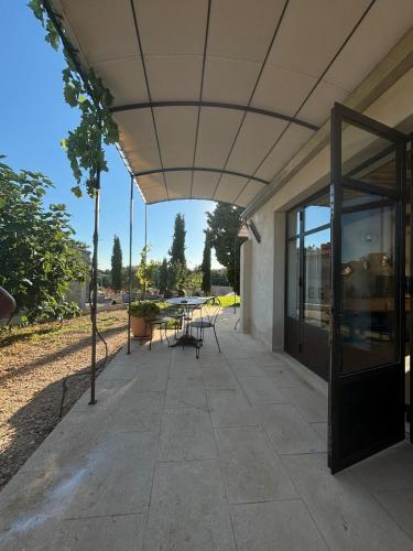 a building with a patio with a table and chairs at Brin d'Olivier en Luberon in Gargas