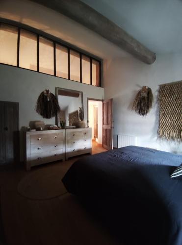 a bedroom with a blue bed and a mirror at Brin d'Olivier en Luberon in Gargas