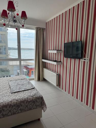 a bedroom with a bed and a tv on a wall at Отдых у моря Одесса in Kryzhanivka