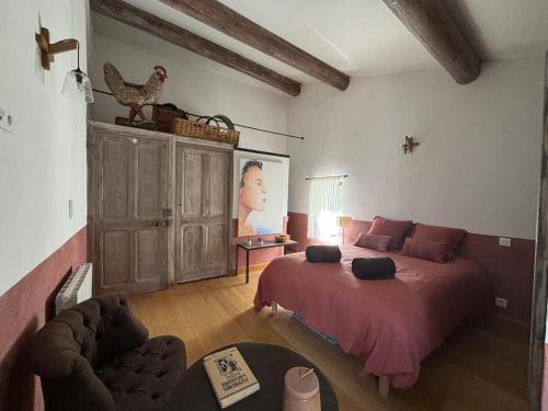 a bedroom with a bed and a couch in a room at Brin d'Olivier en Luberon in Gargas