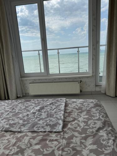 a bedroom with a large window overlooking the ocean at Отдых у моря Одесса in Kryzhanivka