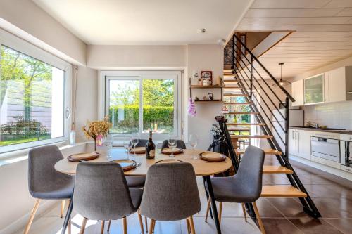 une salle à manger avec une table et des chaises et un escalier dans l'établissement La maison de Kerscovie, à Morlaix