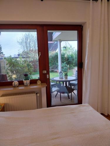 um quarto com uma cama e um pátio com uma mesa em FW Steingraf Waldblick em Stickenbüttel
