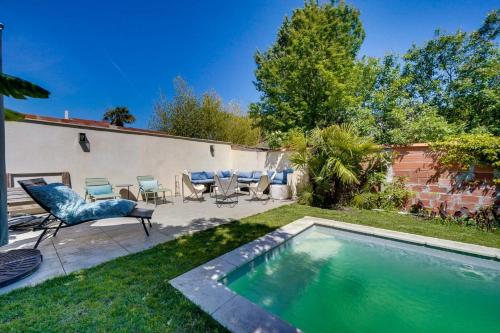 une cour arrière avec une piscine avec des chaises et une table dans l'établissement Très belle Maison avec Piscine et Jardin, à Bordeaux