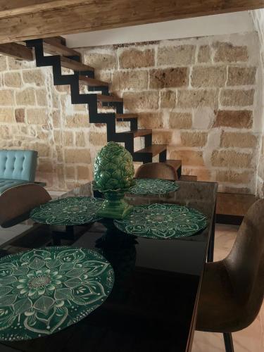 a table with green plates on it with a staircase at La botte in Mesagne