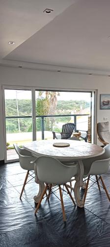 a dining room with a table and chairs in a room at Zambujeiraseahouse - 100m da praia in Zambujeira do Mar
