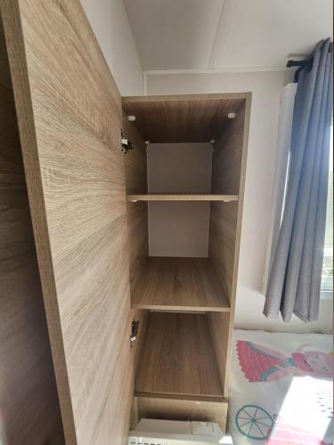 a closet in a bedroom with wooden shelves at Harmonie des Flots in Canet-en-Roussillon