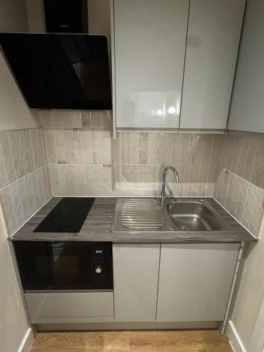 uma cozinha com pia e micro-ondas em Peckham Haven em Londres