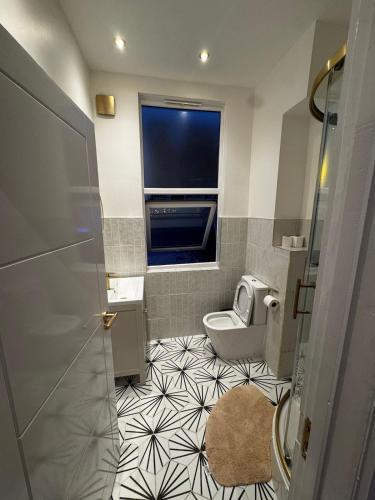 uma pequena casa de banho com um WC e uma janela em Peckham Haven em Londres