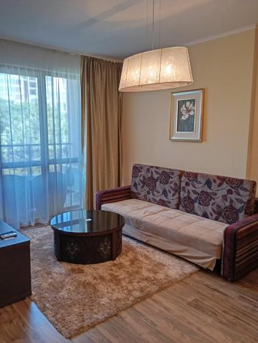 a living room with a couch and a coffee table at Apart Hotel Golden Line private apartments in Golden Sands