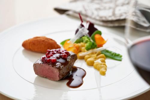 a plate of food with a piece of cake and vegetables at Brugger's Genießerhotel Lanersbacherhof in Tux
