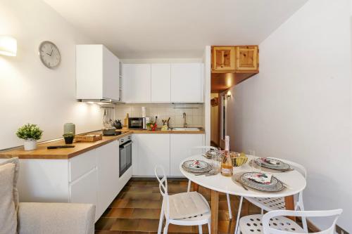 a kitchen with a table and chairs in a kitchen at Appartamento Rio Secco - Happy Rentals in Claviere