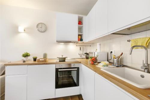 a kitchen with white cabinets and a sink at Appartamento Rio Secco - Happy Rentals in Claviere