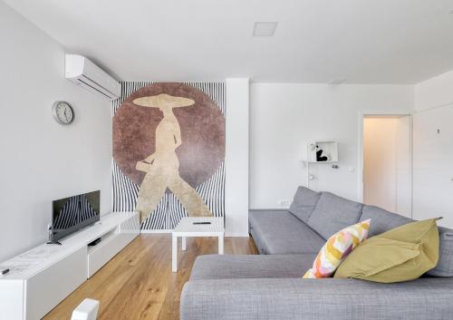 a living room with a gray couch and a hat on the wall at Apartments Trnovo in Ljubljana