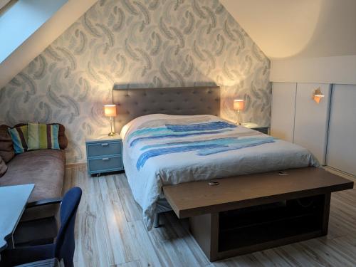 une chambre avec un lit, une table et un canapé dans l'établissement Maison Du cerf - proche du circuit et du golf des 24H, à Mulsanne