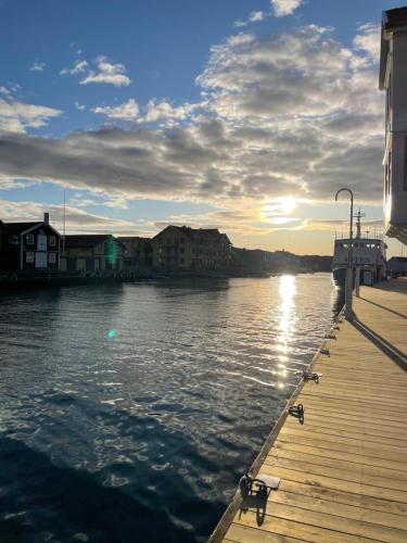 a dock with the sun setting on the water at Pensionat bryggan in Smögen