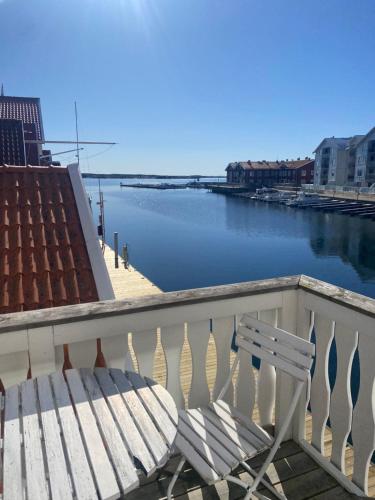 a white bench sitting on a balcony overlooking a river at Pensionat bryggan in Smögen