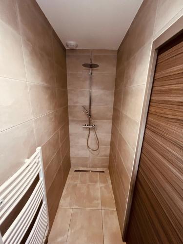 La salle de bains est pourvue d'une douche à l'italienne et de carrelage. dans l'établissement Location villa entre lac et océan avec son spa de nage, à Carcans