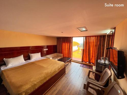 a bedroom with a bed and a tv and a chair at Kodai Cool Stay Home in Kodaikānāl