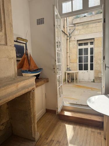 une porte ouverte menant à une chambre dotée d'une grande fenêtre. dans l'établissement lieu cosy, Vieux Port à pied, à La Rochelle