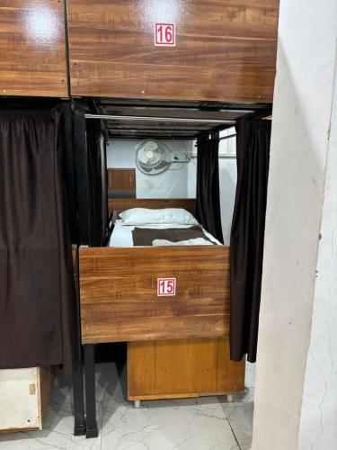 a small bedroom with a bunk bed with wooden walls at aaram ac dormitory in Ahmedabad