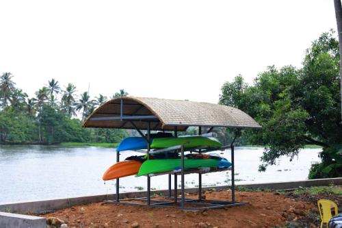 a group of colorful chairs sitting next to a river at Island of Peace Houseboat in Champakulam
