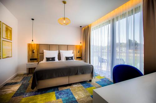 TILIA Resort في دولني كوبين: غرفة نوم بها سرير ونافذة كبيرة