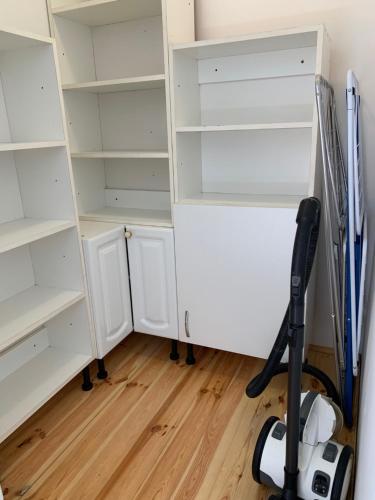 a room with white shelves and a vacuum at Panda apartman in Esztergom