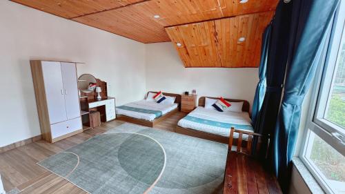 a bedroom with two beds and a large window at Dalat Hills Apartment in Da Lat