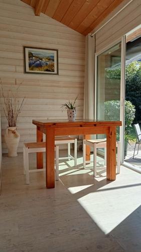 - une table et un banc en bois sur une terrasse couverte dans l'établissement Maison chalet Soustons, à Soustons