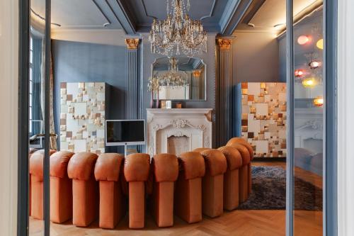 a living room with a couch in front of a fireplace at Hotel De Witte Lelie -Small Luxury Hotels of the World in Antwerp