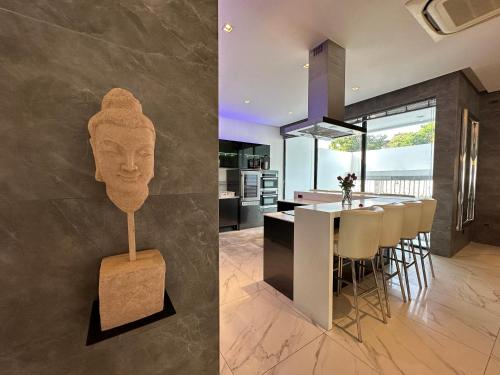 a kitchen and dining room with a statue of a head at Pattaya Near Beach & Walk Street Luxury Villa in Pattaya South