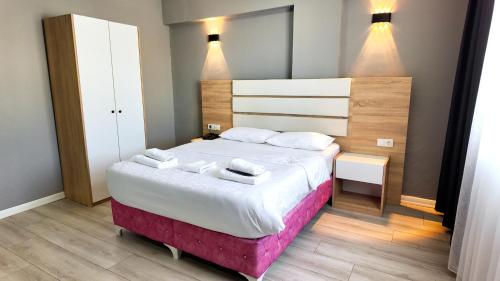 a bedroom with a large bed with two towels on it at RİO's HOTEL KURTKÖY in Istanbul