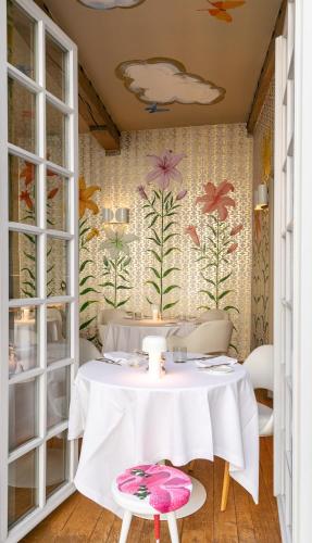 a dining room with a table and a wall with flowers at Hotel De Witte Lelie -Small Luxury Hotels of the World in Antwerp