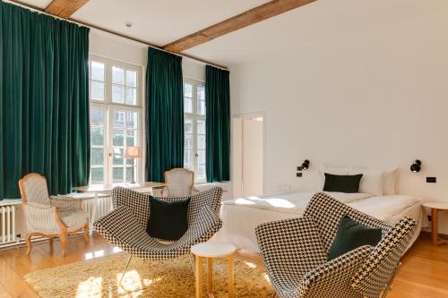 a living room with a bed and some chairs at Hotel De Witte Lelie -Small Luxury Hotels of the World in Antwerp