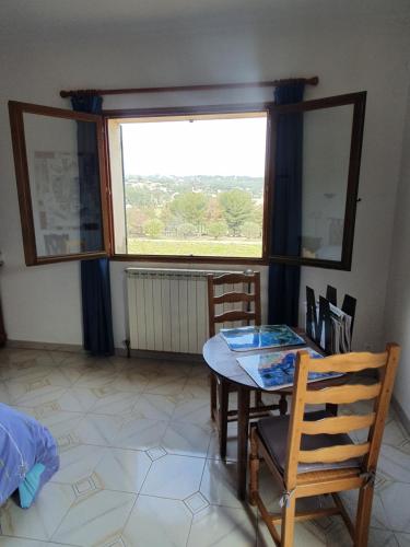 une salle à manger avec une table et des chaises et une fenêtre dans l'établissement La Galline, à La Cadière-dʼAzur
