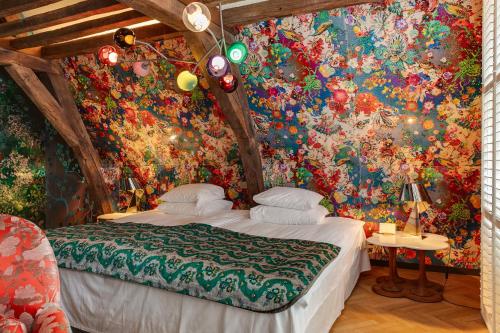 a bedroom with a flowery wallpaper with a bed at Hotel De Witte Lelie -Small Luxury Hotels of the World in Antwerp