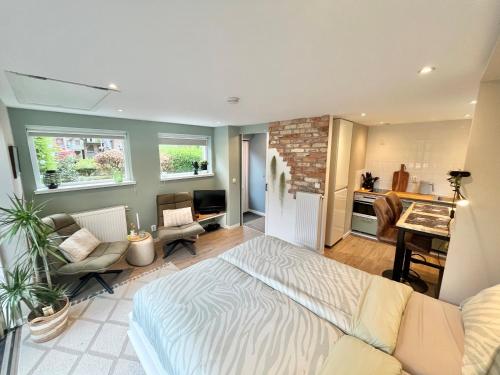 a living room with a bed and a kitchen at Bed and Breakfast Verlaat in Oude-Niedorp