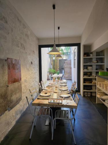 - une grande table en bois avec des chaises dans l'établissement Maison des Remparts Intra-Muros spacieuse Patio avec Bassin Wifi Parking Gratuit, à Aigues-Mortes