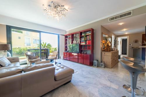 un salon avec un canapé et une télévision dans l'établissement 3-Br Apartment with Private Pool & Sea View, à Cannes